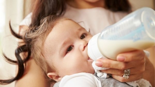 happy baby being fed with bottle