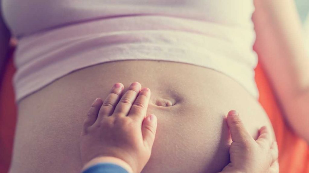 toddler hands on pregnant tummy