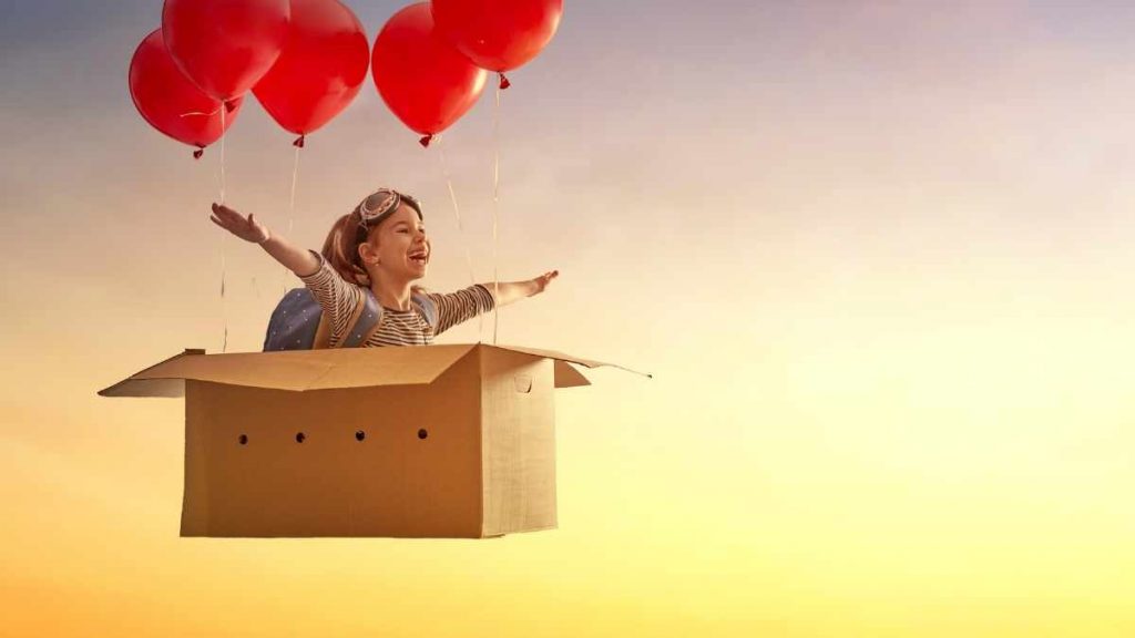 lady in a box with balloons holding her in the air