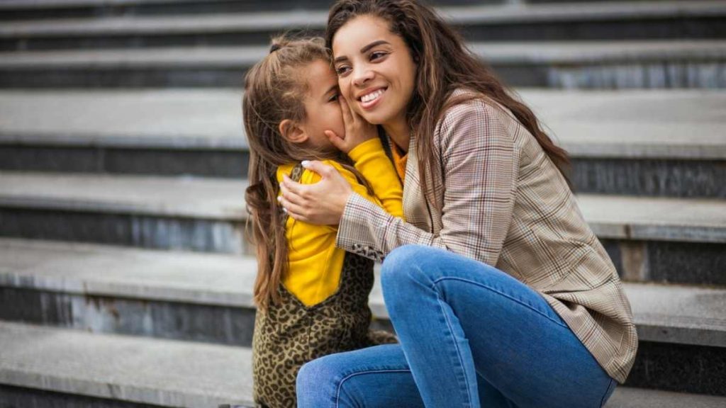 toddler whispering in moms ear