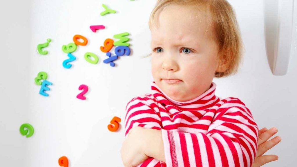 toddler with arms crossed looking defiant