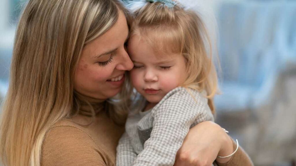 toddler girl hugging mom sign of empathy
