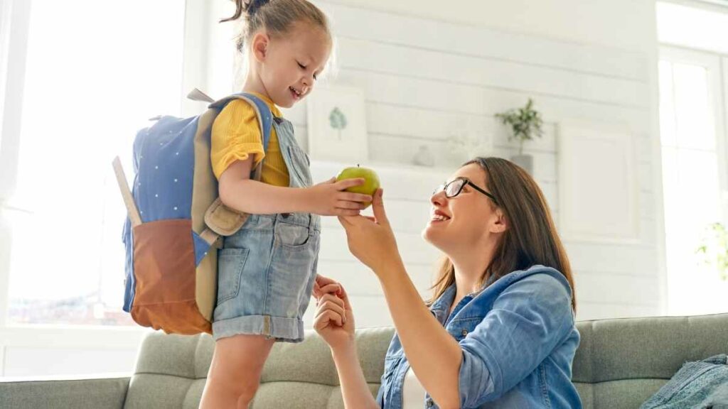 preschooler getting apple from mom