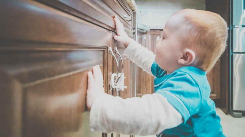 baby trying to get into locked cabinet