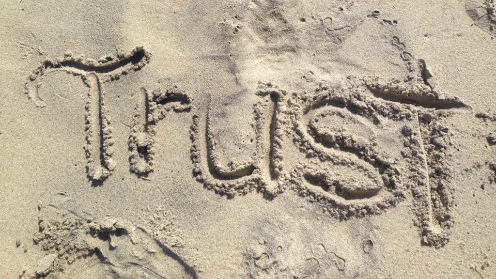 the word trust in sand