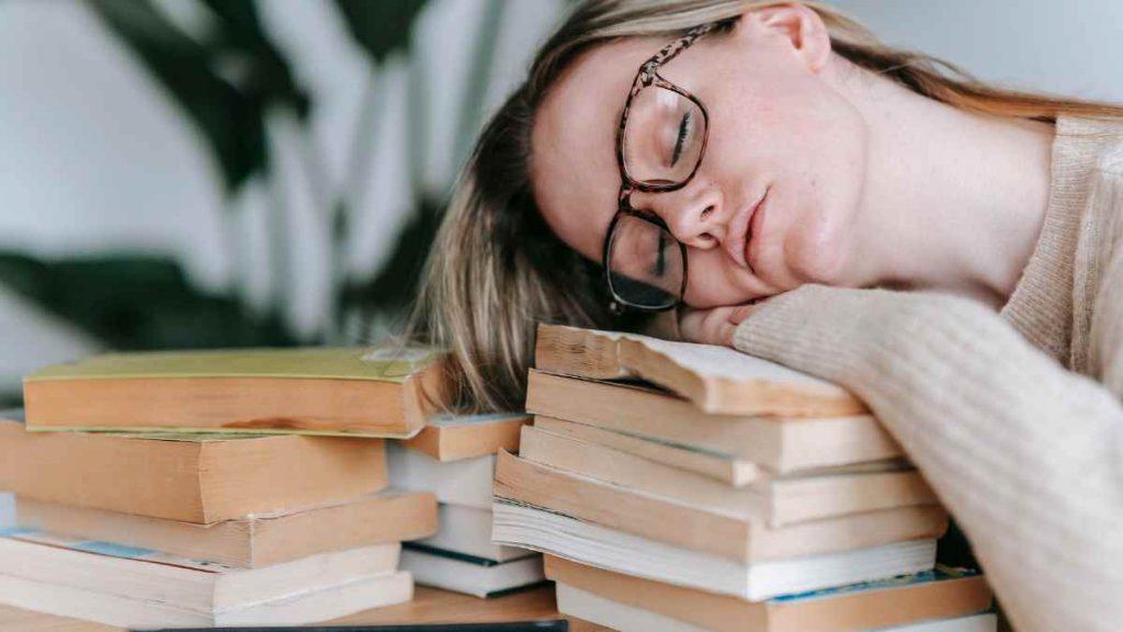 lady asleep on books