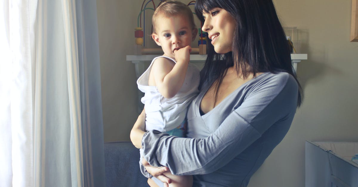 woman-carrying-girl-while-showing-smile