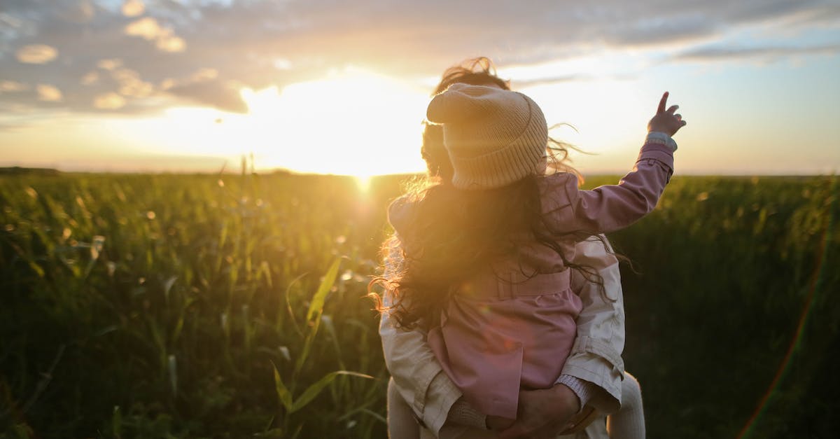 woman-carrying-girl-while-showing-smile