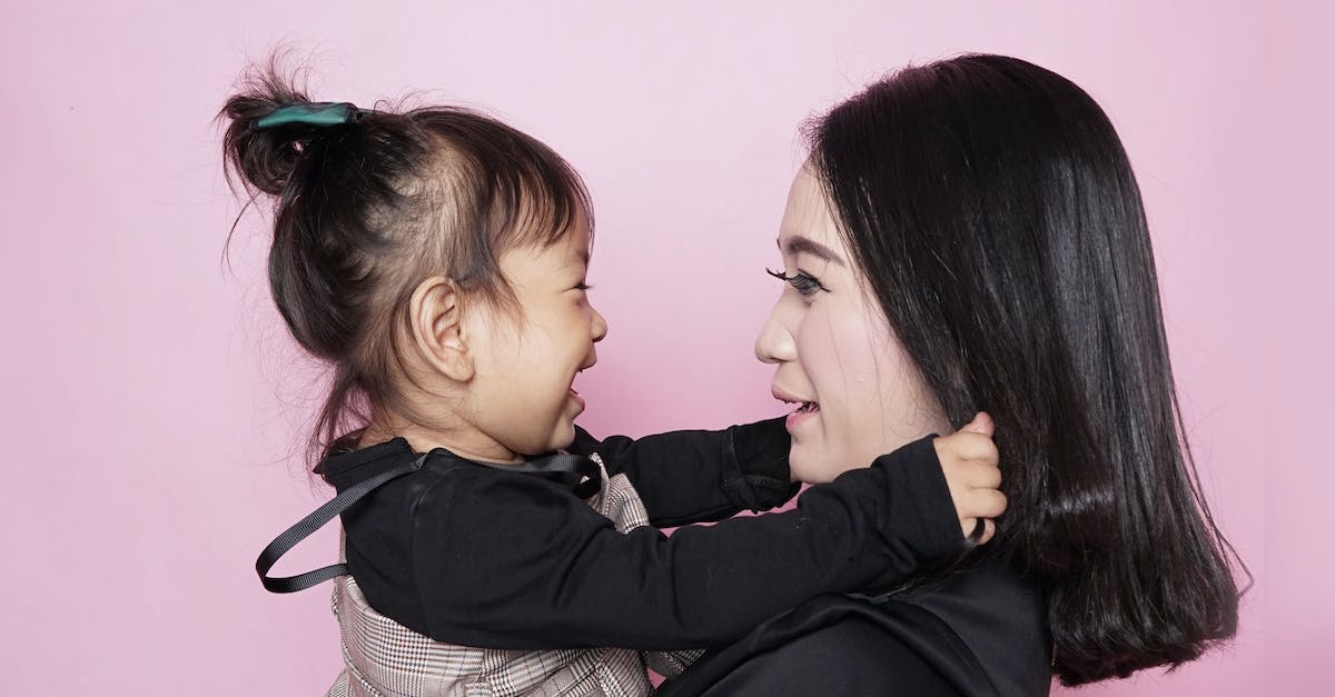 woman-carrying-girl-while-showing-smile